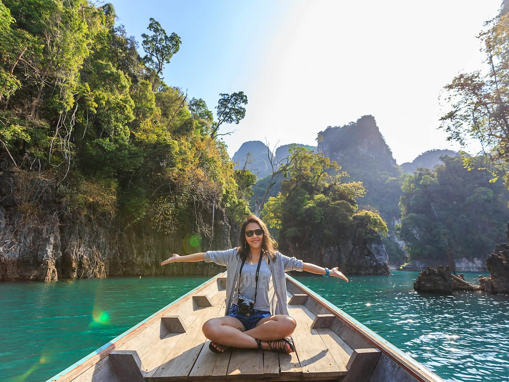 photo of woman sitting on boat spreading her arms