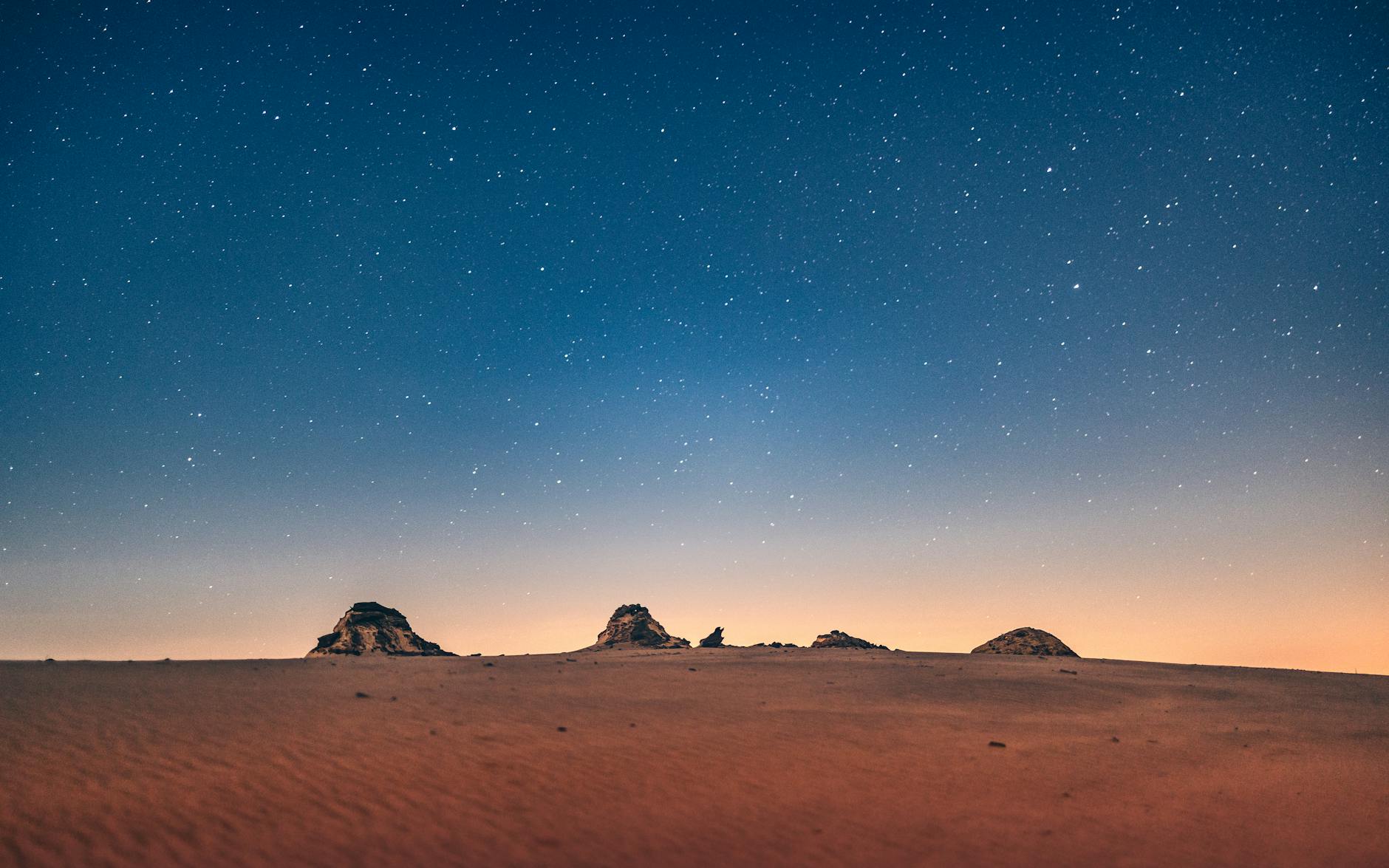 brown sand under blue sky during night time