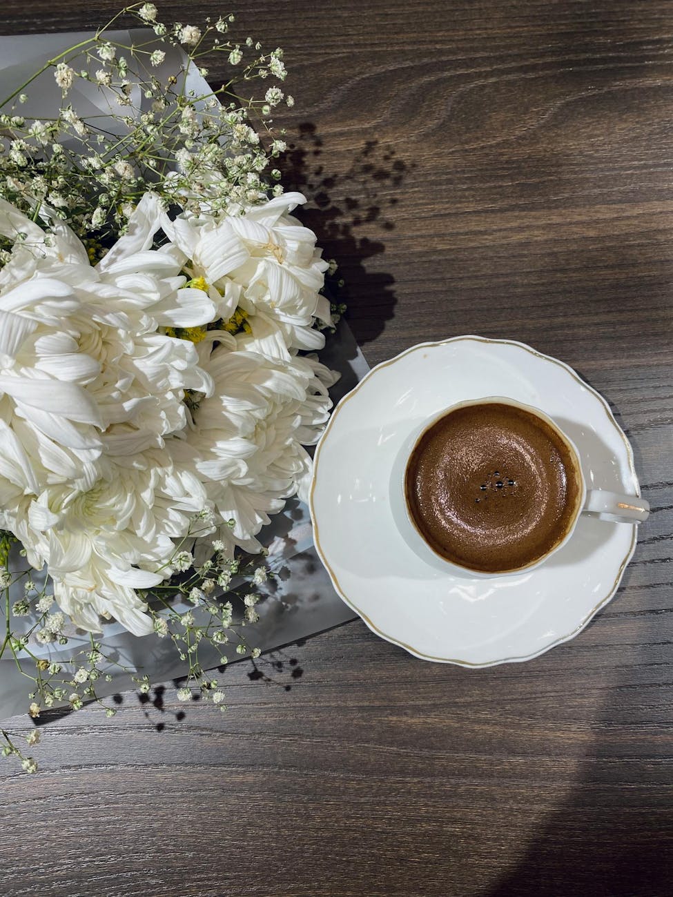 elegant cup of coffee with white floral arrangement