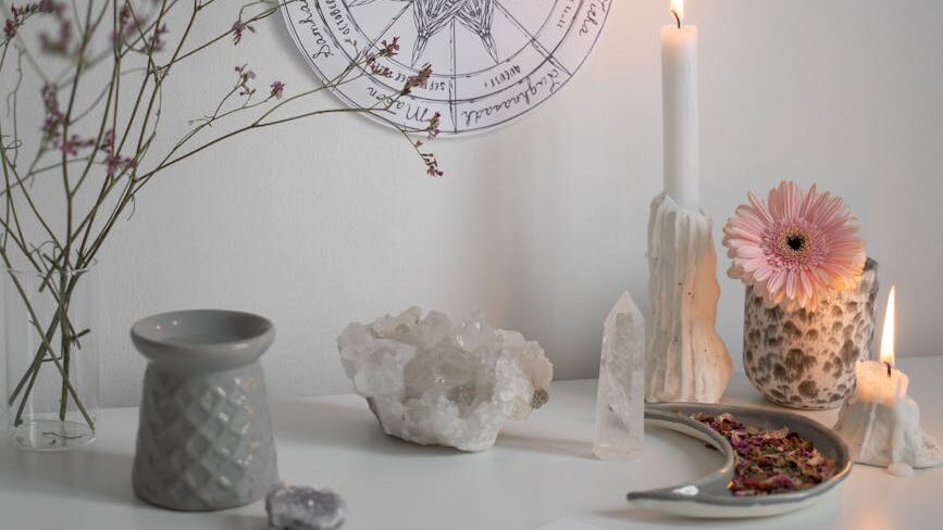 burning candle and crystals by wheel of year on wall