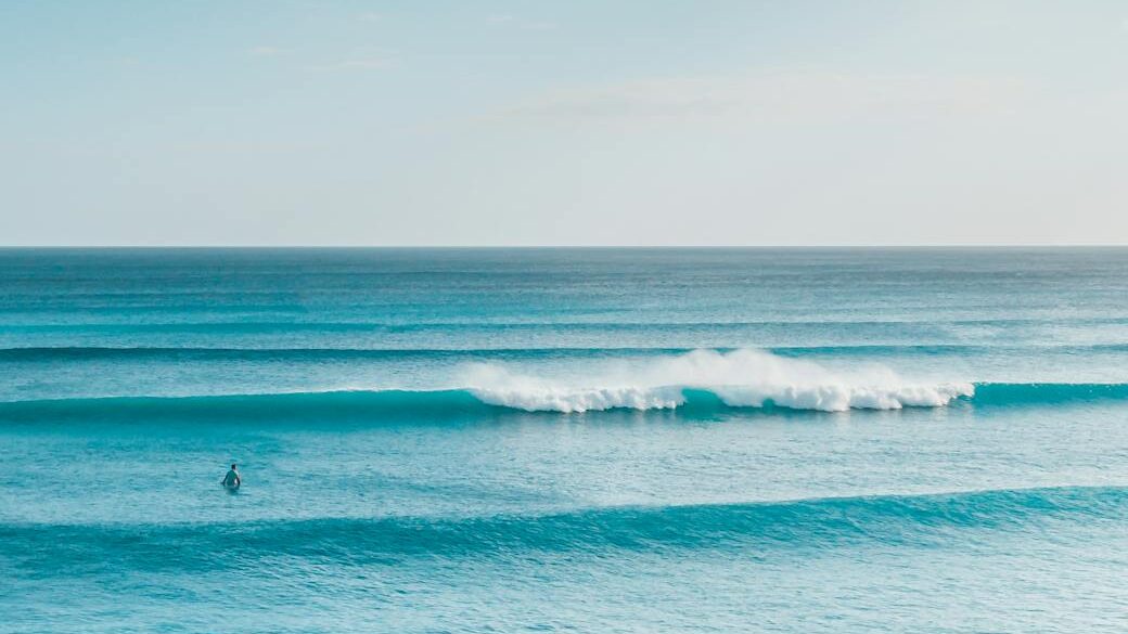 ocean waves under blue sky and white clouds